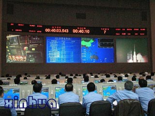 这是北京航天指挥控制中心里的科技人员精心操作,一丝不苟.